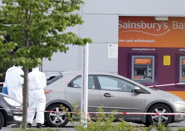 Forensic experts pictured beside a car which has had its rear window damaged.   Picture by Jonathan Porter/PressEye.com