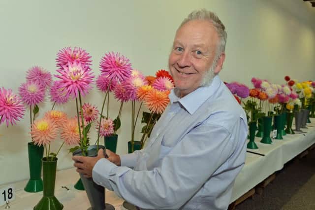 Charles Holmes shows off his prizewinning dahlias at the flower show. INLT 34-032-PSB