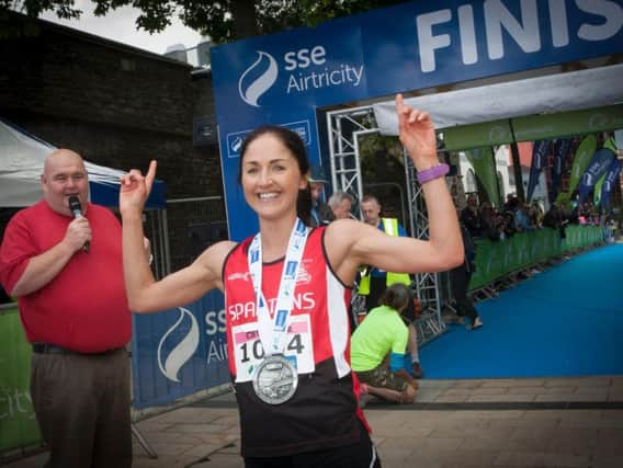 City of Derry Spartan Catherine Whoriskey crosses the finish line to line the Women's race at the SSE Airtricity Walled City Marathon on Sunday.