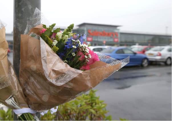 Flowers left at the scene of Colin Horner's murder in the carpark of Sainsbury's in Bangor. Pic by Pacemaker