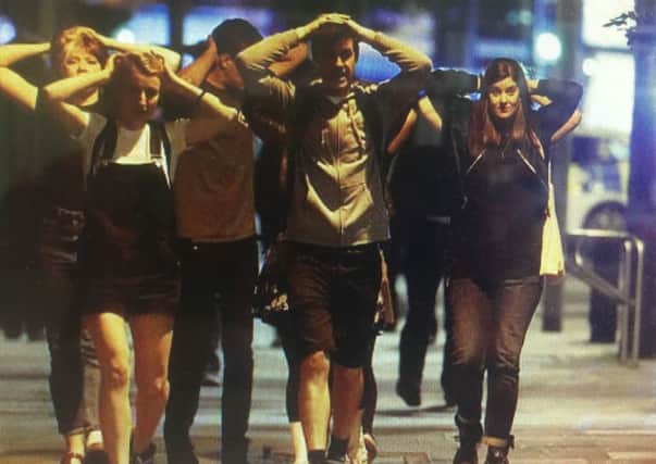 Amy and Ryan with their hands on their heads as they emerge from the restaurant in the Borough Market area which was targeted by terrorists on Saturday night.