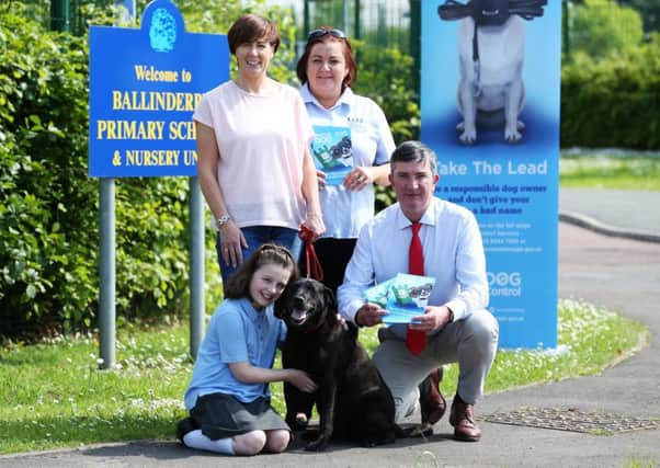 Prize winner Nikki Brown, Emma Brown and dog Jet with Enforcement Officer Joanne Macaskill and Chairman of the Environmental Services Committee Councillor James Baird outside Ballinderry Primary School.