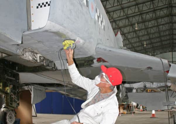 Supersonic Surgeon: David Hart of Carrickfergus applies a sander to a Phantom jet fighter, as a volunteer with the Ulster Aviation Society.