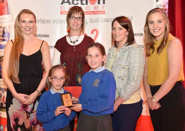 Savannah Cully, Grace Cully (teacher) and Kirsten Cully from Ballinderry Primary School collect their Gold award from Zoe Salmon; Jennifer Morton, Centra and Rebecca Dalzell, Action Cancer.