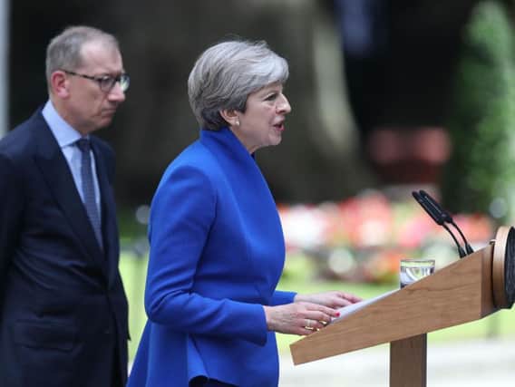 Prime Minister Theresa May, accompanied by her husband Philip, makes a statement in Downing Street after she traveled to Buckingham Palace for an audience with the Queen