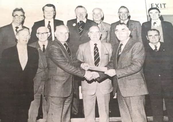 Mr Austin Fulton, chairman of the Union Street branch of the Royal British Legion presents a cheque to Poppy Appeal organiser Len McCreanor in 1984