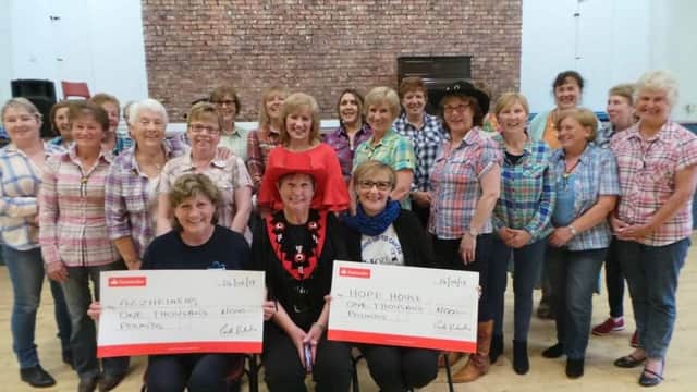 Noreen Hill for Alzheimers and Dawn McConnell from Hope House receive cheques for Â£1,000 from Linda Valentine on behalf of herself and her line dancing class which runs in Whitehead Community Centre. Linda raised the money by saving up her class entrance fees.