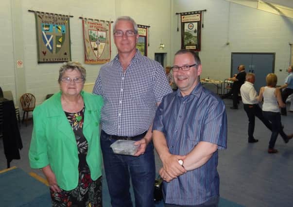 Andy Bisp (centre) hands over a donation of Â£406 towards the running of Ballycarry Community Centre to Valerie Beattie, Chairperson of Ballycarry & District Community Association, and Dr. David Hume, treasurer.