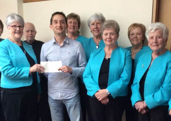 Members of Counterpoint Choir including Chairperson, Jenni Power, presenting the cheque to Dave Morton of Quaker Service