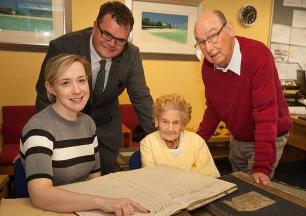 Shirin Murphy, Collections Access Officer at Carrickfergus Museum and Sarah McMurran look at a collection of old Carrick school registers.. Included are Gareth Hamilton, outgoing principal of Sunnylands Primary and Bobby Todd.