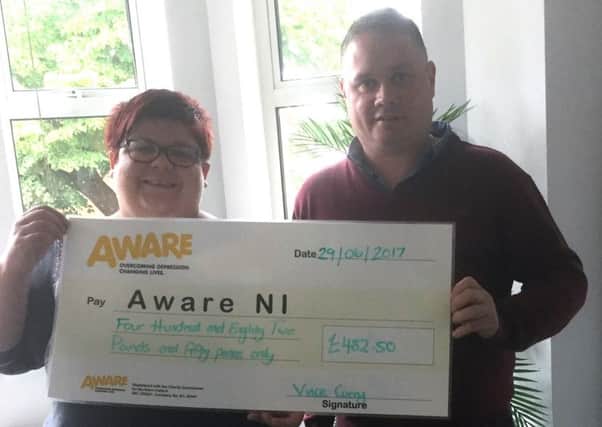 Joy Goodall, Fundraising Coordinator for Aware NI, receives a cheque for Â£482.50 from Vince Curry, Technical Business Link Worker for Resurgam Trust.
