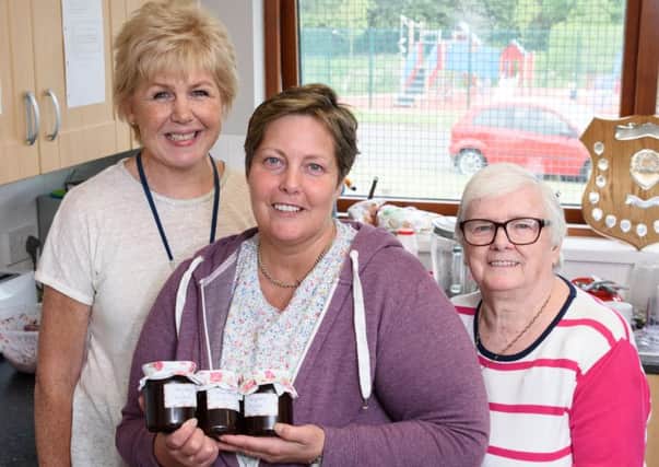 Housing Executive Housing Officer, Margaret Alister, meets cookery club members, Ann Balmer and Doreen Wylie, who are preparing homemade strawberry and rhubarb jam for sale.