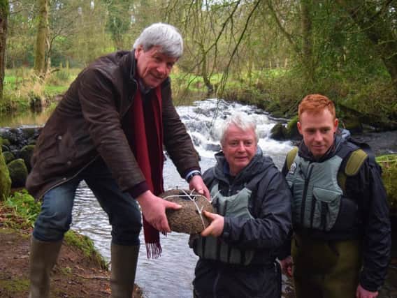 Frank Mitchell and David Bell of the Ballinderry Rivers Trust show Joe a silo which houses freshwater pearl mussels in Lissan Water.