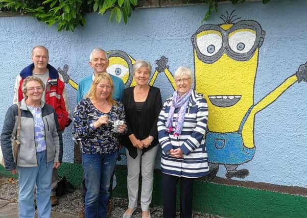 Members of the Cullybackey Community Partnership L R Elizabeth Boyd, Patrick Fisher, Bertie McNeilly, Margaret Murphy and Ruth Orr are pictured with local artist Mary Cochrane