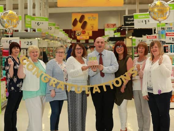 Asda colleagues Joanne McGuigan, Penny Eakin, Valerie Connor, Anne Storey, Christopher Patton, Karen Wall, Hazel Irwin, and Vivienne Campbell celebrate '300 years' in the business as each colleague celebrates 30 years with Asda.