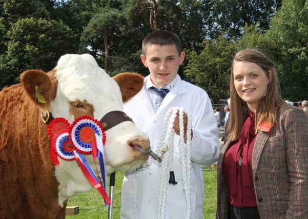 Jason Whitcroft, Antrim, won the Simmental championship at the Randox Antrim Show. He is pictured with judge Zara Clarke from Armagh. Picture: Julie Hazelton
