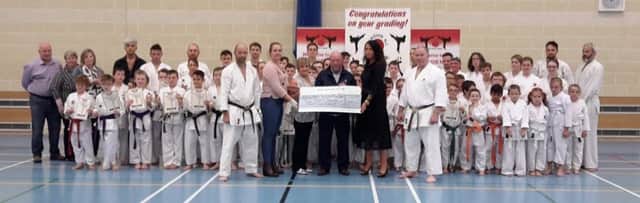 The Geddis Family along with members of the Zanshin Shotokan Karate Club, friends, family and Sensei Brennan 8 th Dan from the Karate Union of Great Britain presenting the Kevin Bell Reparation Trust with a cheque for Â£10,000.