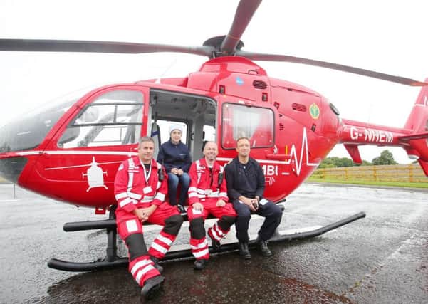 Eleven-year-old Conor McMullan pictured beside one of the air ambulance helicopters with (left to right) air doctor Darren Monaghan, paramedic Glenn O'Rourke and pilot David O'Toole . Conor, from Castlewellan, was the first people to use the air ambulance after he was involved in an accident and the helicopter was diverted from a training exercise. Pic by Jonathan Porter, PressEye
