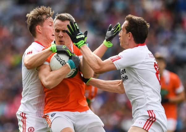 Mark Shields of Armagh is tackled by Kieran McGeary and Colm Cavanagh, right,  of Tyrone