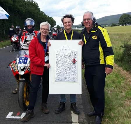 Jann Simm of the Injured Riders Welfare Fund, receives a shirt signed by all of this years Armoy riders from AMRRC member Brandon McKillip. Also present is Clerk of the Course, Bill Kennedy MBE.