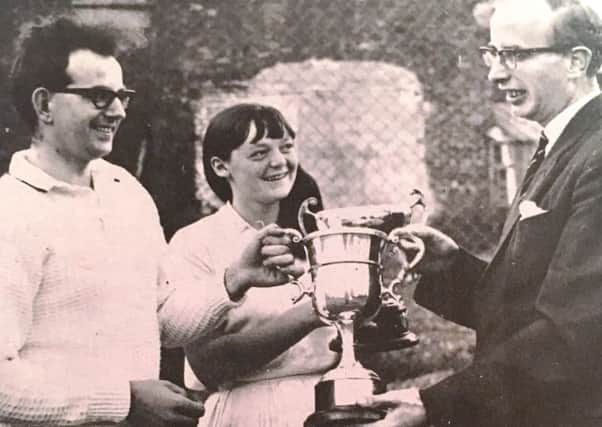 R Lucas, captain of Downshire Tennis Club in 1969 receives the Senior League Cup from Mr JH McCartney, league honorary secretary. Also pictured is ladies captain Miss Lettie McClenaghan with the Junior League Cup