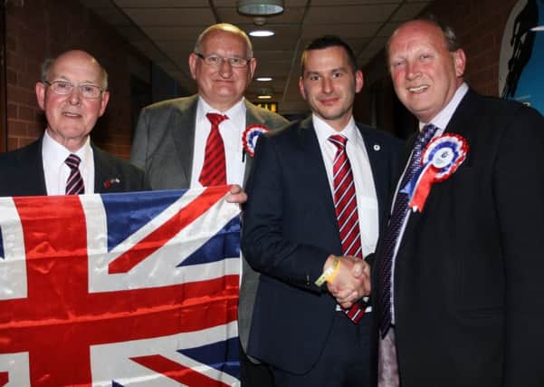 The TUV's Timothy Gaston shakes hands with party leader Jim Allister after being elected to Mid and East Antrim Council in 2014. Looking on are Roy Gillespie (left) and Mr. Gaston's father, Sammy. INBT22-231AC