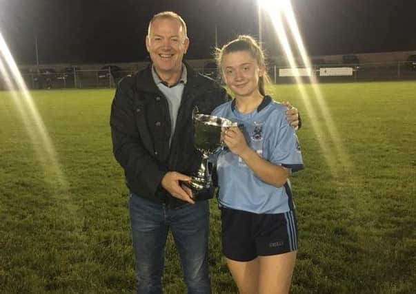 Captain Grace Ferguson accepting the cup from Armagh ladies' chairman Paul Doherty.