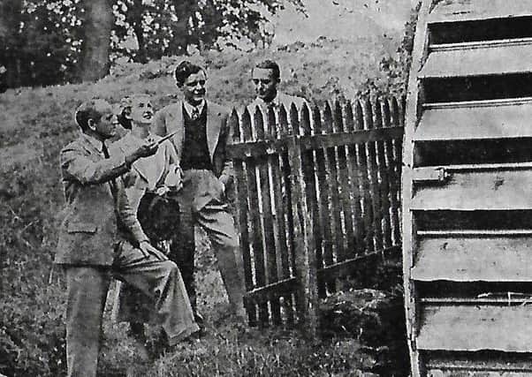 Richard Hayward (left) with Kay Walsh, Niall McGuinness and Donovon Pedelty at the old mill wheel at Glynn during the filming of Luck of the Irish in 1936.