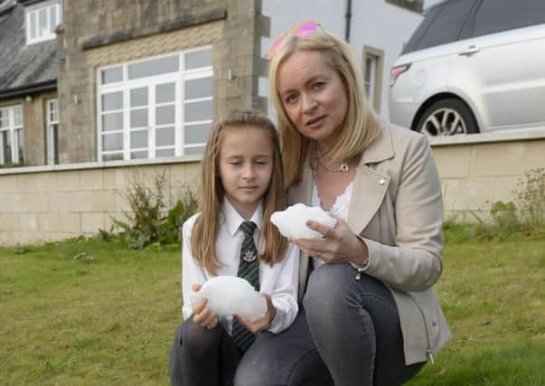 Lyndsey Helliwell and her daughter Elise in their garden in Busby, Glasgow, Scotland, where a large block of ice fell out of the sky