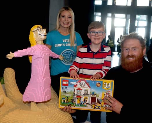 Charlie Carson (9), the winner of the LEGO building competition at the Giant's Causeway. Charlie is pictured receiving his prize with Jennifer Michael from the National Trust and surfer Al Mennie beside the LEGO Sophie from The BFG, on loan to the site from the Roald Dahl Literary Estate.