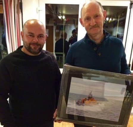 Larne RNLIs Fish Supper raffle winner  John Stirling (right) receives  his prize from photographer Trevor Hartnett who donated the prize.