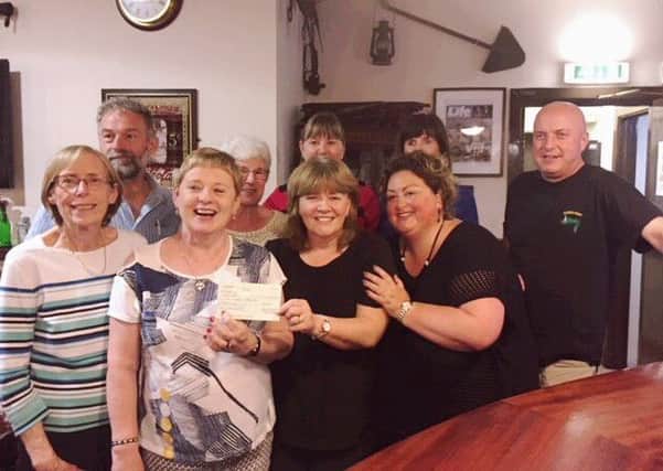 Organisers and supporters  of the recent Cairncastle Community Association  annual charity quiz in aid of PRAXIS presenting the Â£252 raised on the night to Jackie, manager from PRAXIS which empowers adults and children with mental ill health, learning disabilities or acquired brain injury to enjoy every day living.