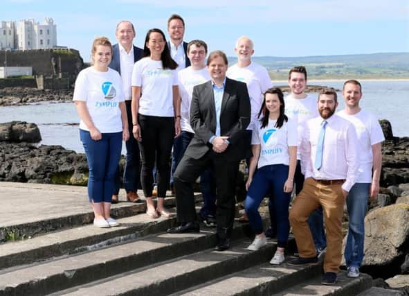 CEO of Zymplify Michael Carlin, centre, with his current team at Zymplify Portstewart.