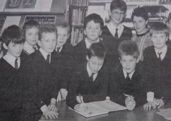 Pupils of Buick Memorial PS sign the visitors book on their visit to Cullybackey High School. (1989)