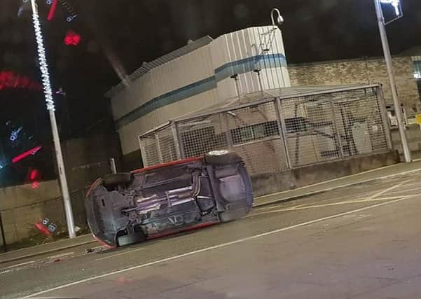 A car on its side in front of Lurgan police station