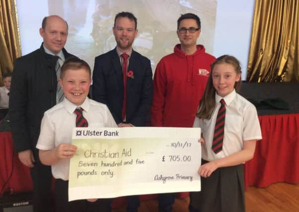 Principal of Ashgrove Primary Mr Smith, Pastor Timothy Hair and P7 pupils hand over a cheque to David Thomas from Christian Aid.